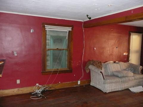 Dimly lit room with red walls and wooden floors