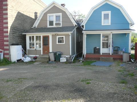 Two small houses with dormer roofs are side by side.